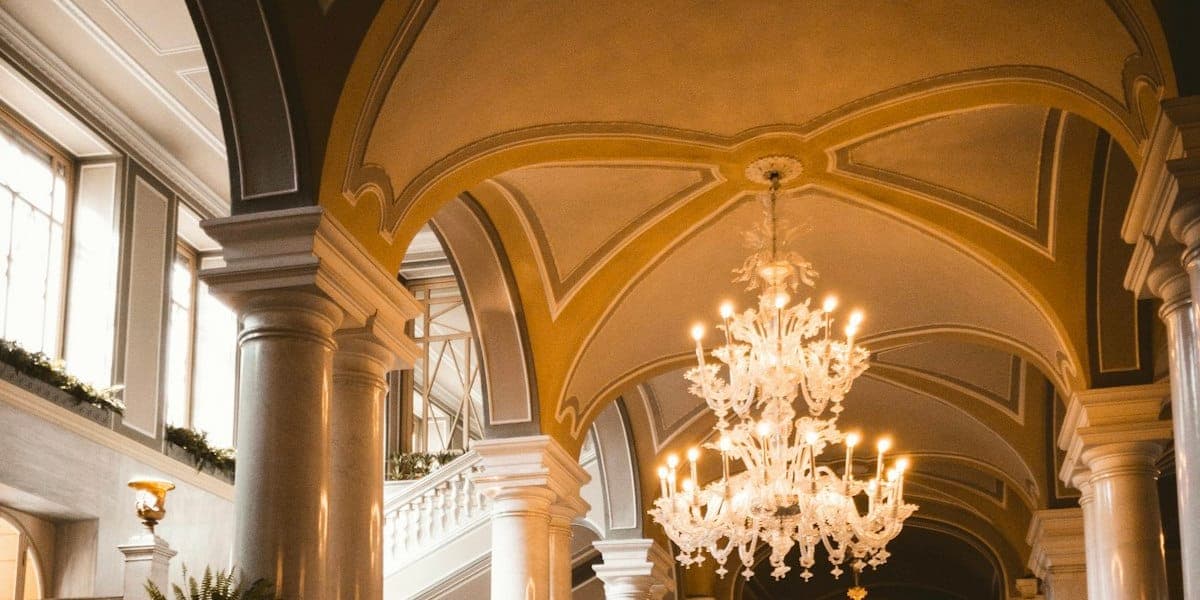 Hall d'hôtel voûté, lustres et escalier de pierre