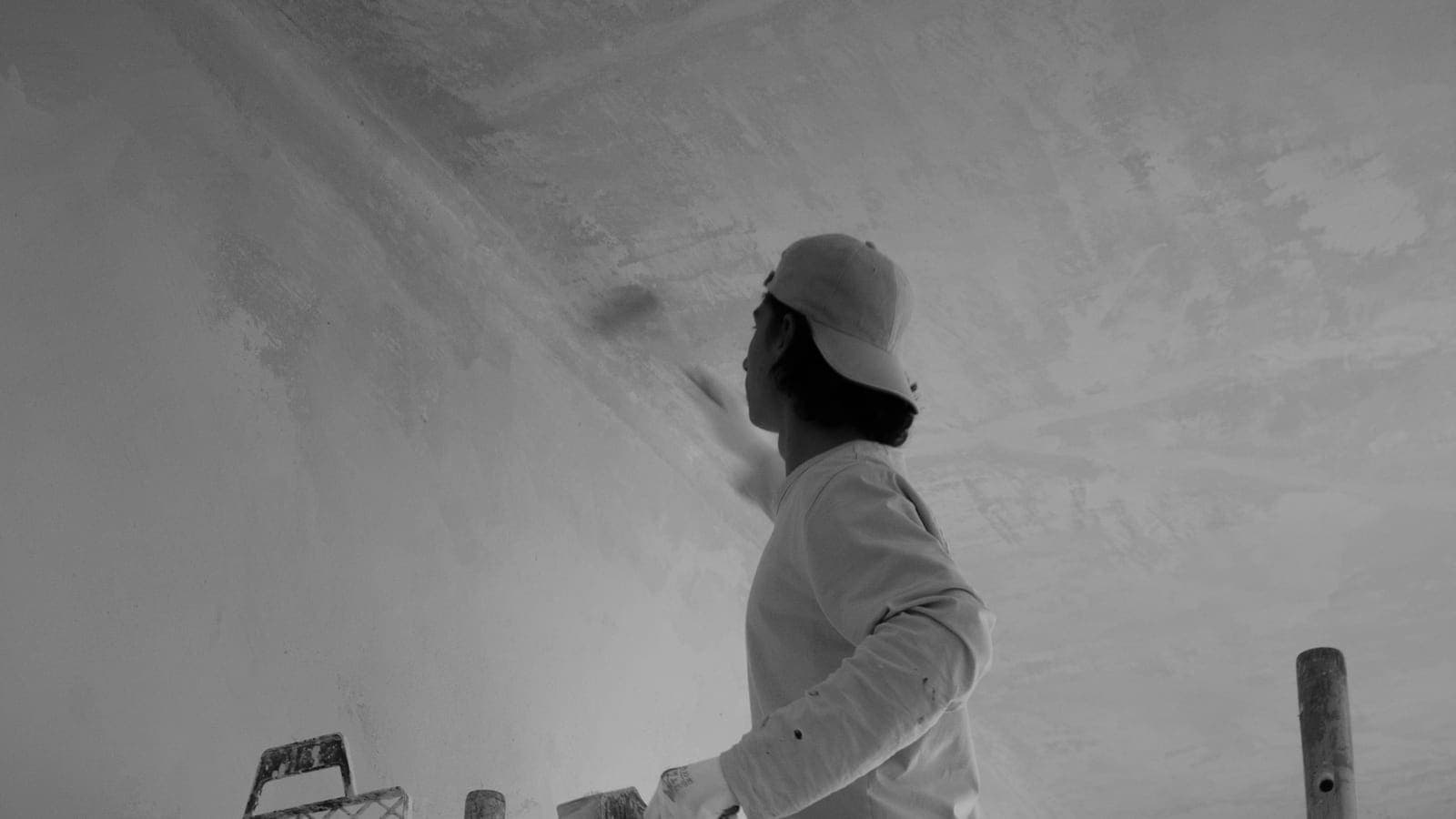 Application d'une finition en jonction de mur et de plafond depuis un échafaudage roulant