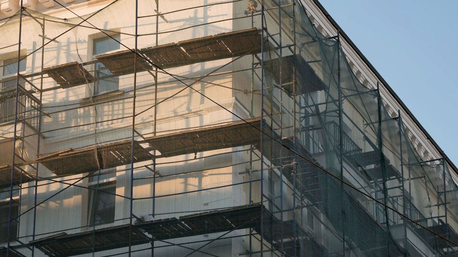 Immeuble ancien ceinturé d'échafaudages et de filets pour des travaux d'enveloppe